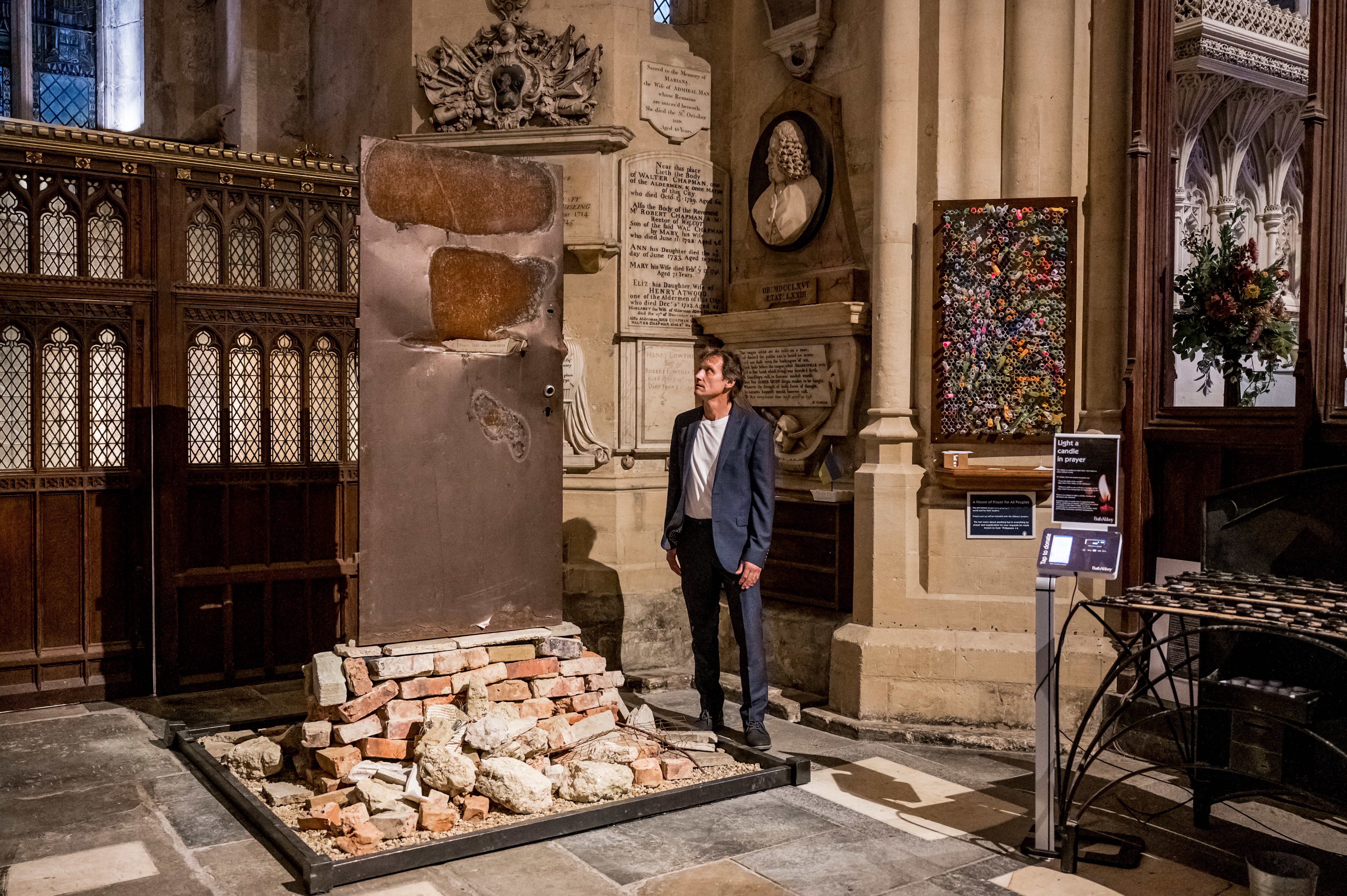 An installation of a bombed and damaged door from Ukraine by artist Robert Marshall, within the setting of a church