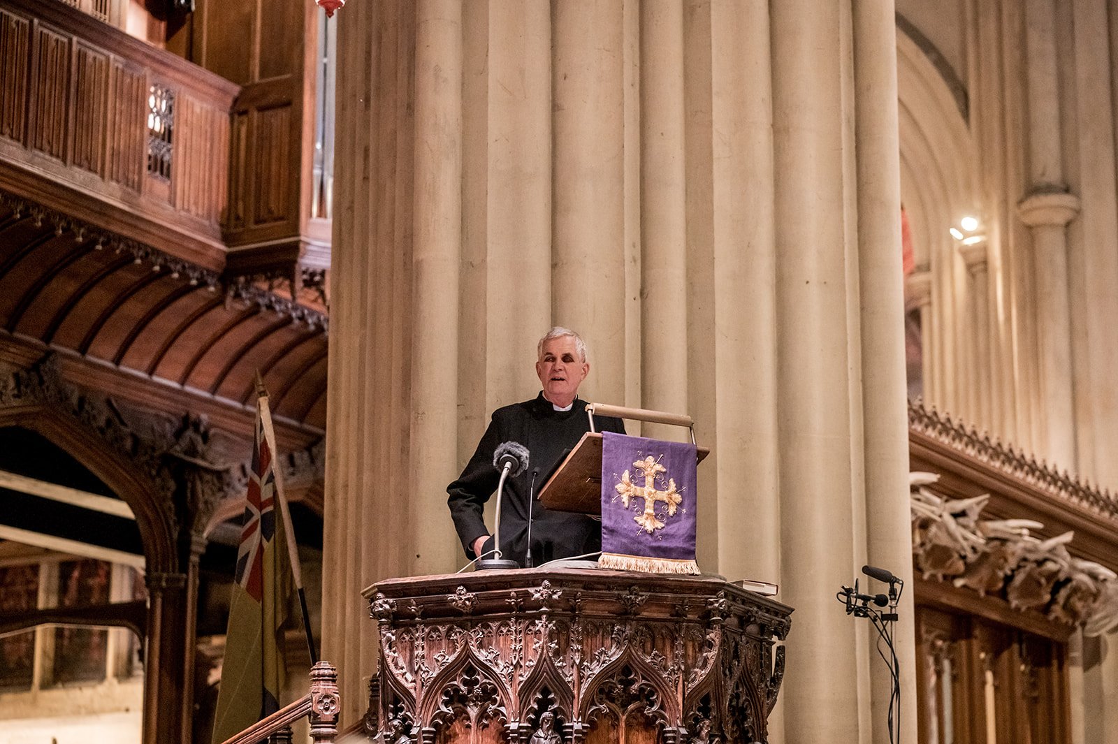 A member of the clergy preaches from the pulpit