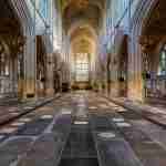 Memorial ledgerstones on Bath Abbey's floor, looking down the nave towards the altar and east window