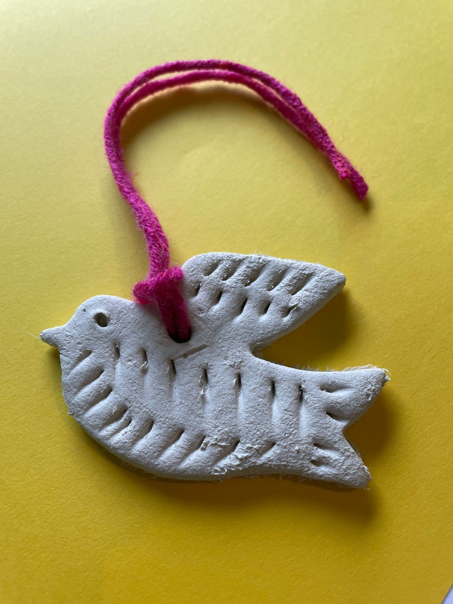 a small clay bird shape on a string.