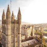 A church tower with the city and sky behind